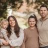 a family posing for a photo in front of some trees