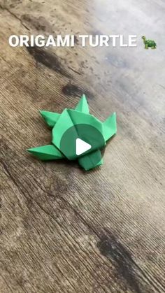 an origami turtle sitting on top of a wooden table