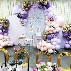 an image of a birthday party setting with balloons and flowers on the table in front of it