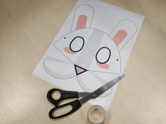 a pair of scissors sitting on top of a piece of paper with a bunny cut out