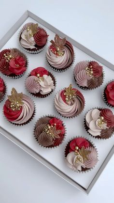 twelve cupcakes with red, white and gold frosting in a silver box