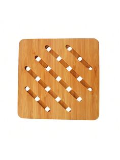 a bamboo cutting board with holes in the middle and white squares on it, against a white background