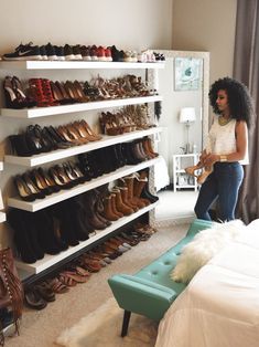 a woman standing in front of a shoe rack filled with shoes