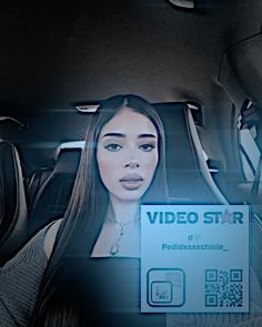 a woman sitting in the back seat of a car holding up a video star sign