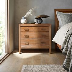 a bedroom scene with focus on the bed and nightstands, along with an open window