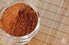 a glass bowl filled with spices on top of a bamboo mat