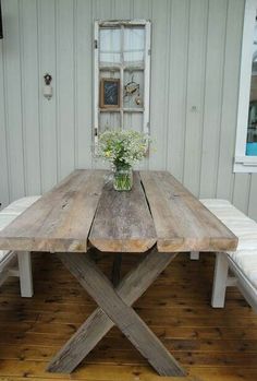 a wooden table sitting on top of a hard wood floor next to a white wall