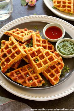 some waffles are on a plate with dipping sauce