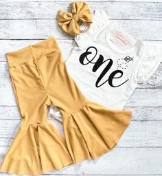 two pieces of clothing with the word one on it and a bow at the top