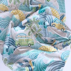 a blue and green fabric with an image of a bus on the ocean wave pattern