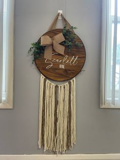 a wooden sign hanging from the side of a wall with a bow on it's head