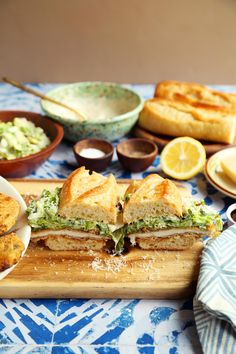 a sandwich cut in half sitting on top of a cutting board next to other foods