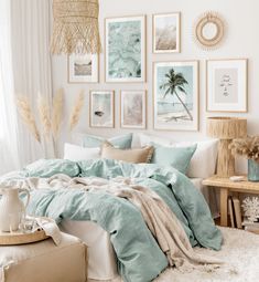 a bedroom with pictures on the wall and a bed covered in blue sheets, blankets and pillows