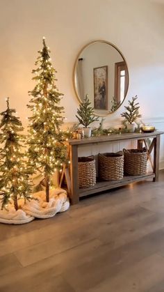 christmas trees and baskets in front of a mirror on the floor with lights around them