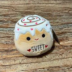 a small rock with a cute face painted on it and the words sweet written in cursive writing