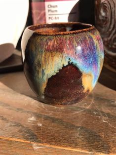 a colorful vase sitting on top of a wooden table