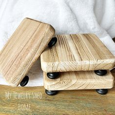 two wooden coasters sitting on top of a table next to a white towel and some black wheels