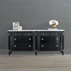 a black and white dresser with flowers on top