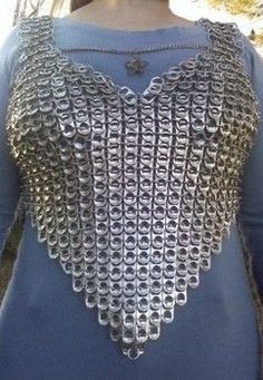 a woman wearing a blue top with silver chains on it's chest and back