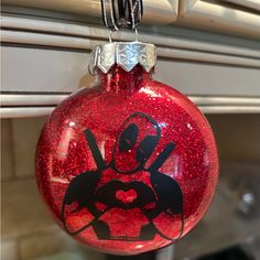 a red ornament hanging from a window with a star wars logo on it