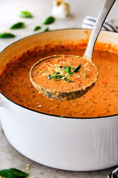 a ladle full of soup being held by a spoon