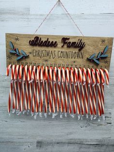 a wooden sign hanging from the side of a wall with candy canes in it