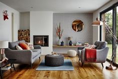 a living room with two couches and a fire place in it's center