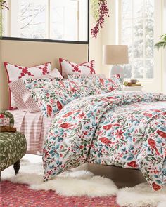 a bed room with a neatly made bed next to a window and rugs on the floor