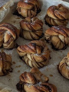 several pastries sitting on top of a piece of parchment paper covered in powdered sugar