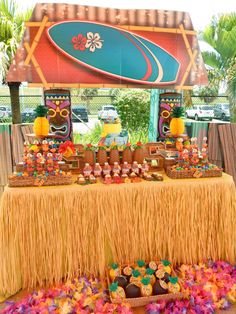 the dessert table is set up with tiki decorations