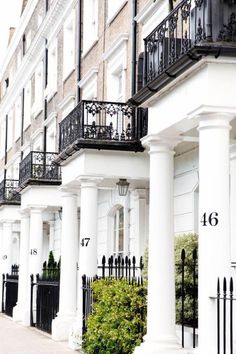 a row of white buildings with black balconies