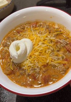 a bowl of chili with cheese and sour cream