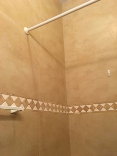 a bathroom with a toilet, shower head and tiled walls in the shower stall area