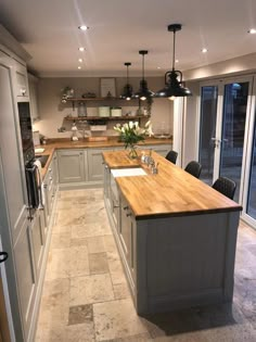 a large kitchen with an island and wooden counter tops