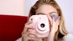 a woman taking a photo with her pink camera