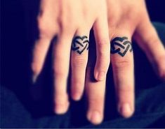 two people with tattoos on their fingers