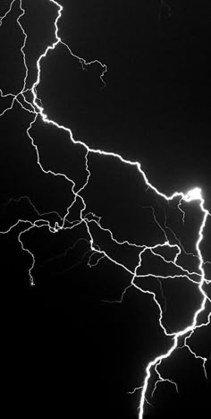 lightning strikes across the night sky in this black and white photo taken from an airplane