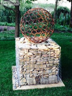 a metal ball sitting on top of a pile of logs