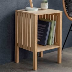 a wooden side table with books and a potted plant