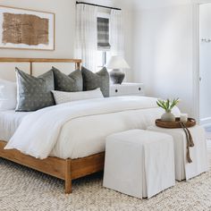 a bed with white linens and pillows in a bedroom