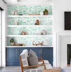 a living room filled with furniture and shelves covered in green bamboo leaf print wallpaper