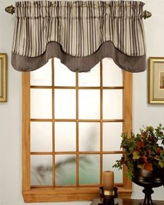 a window with a striped valance over it and a potted plant next to it