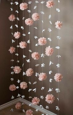 pink and white paper flowers hanging from the ceiling