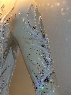 a pair of white ballet shoes covered in crystal beads and sequins on display