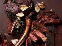 steak with garlic and mushrooms on a cutting board next to a glass of red wine