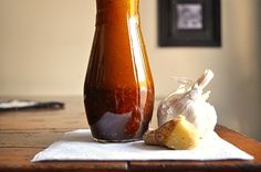 a table with a vase and garlic on it, next to a bag of garlic