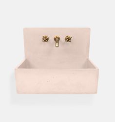 a white sink with two golden knobs on it