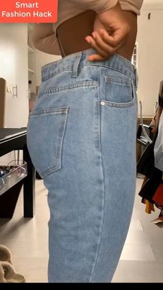 a woman is showing off her jeans in the mirror