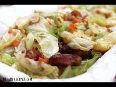 a salad with lettuce, carrots and bacon in a white paper container