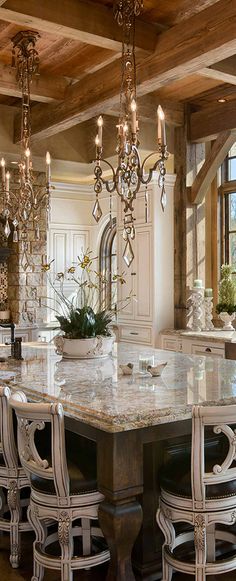 an elegant kitchen with marble counter tops and chandeliers